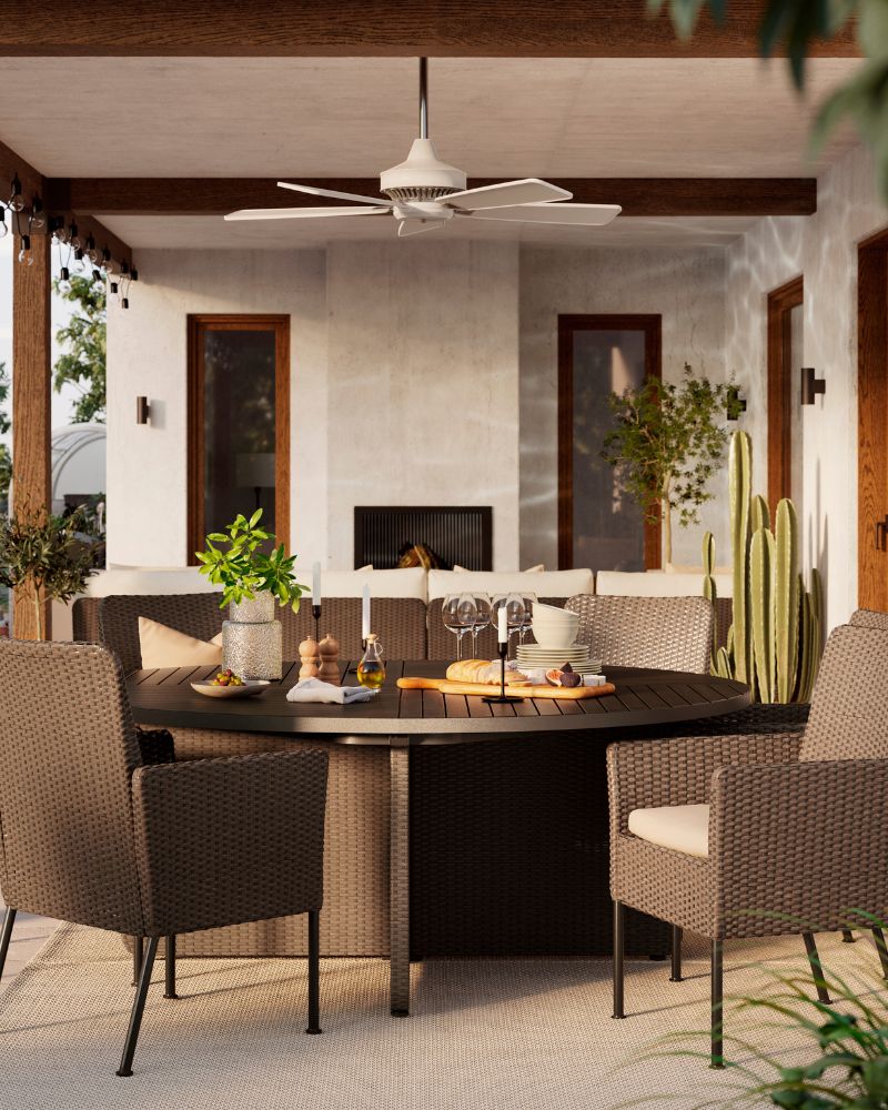 Una comedor exterior a la luz del día, con seis amplias sillas de comedor VITTSKÄR en color gris oscuro y una mesa redonda a juego.