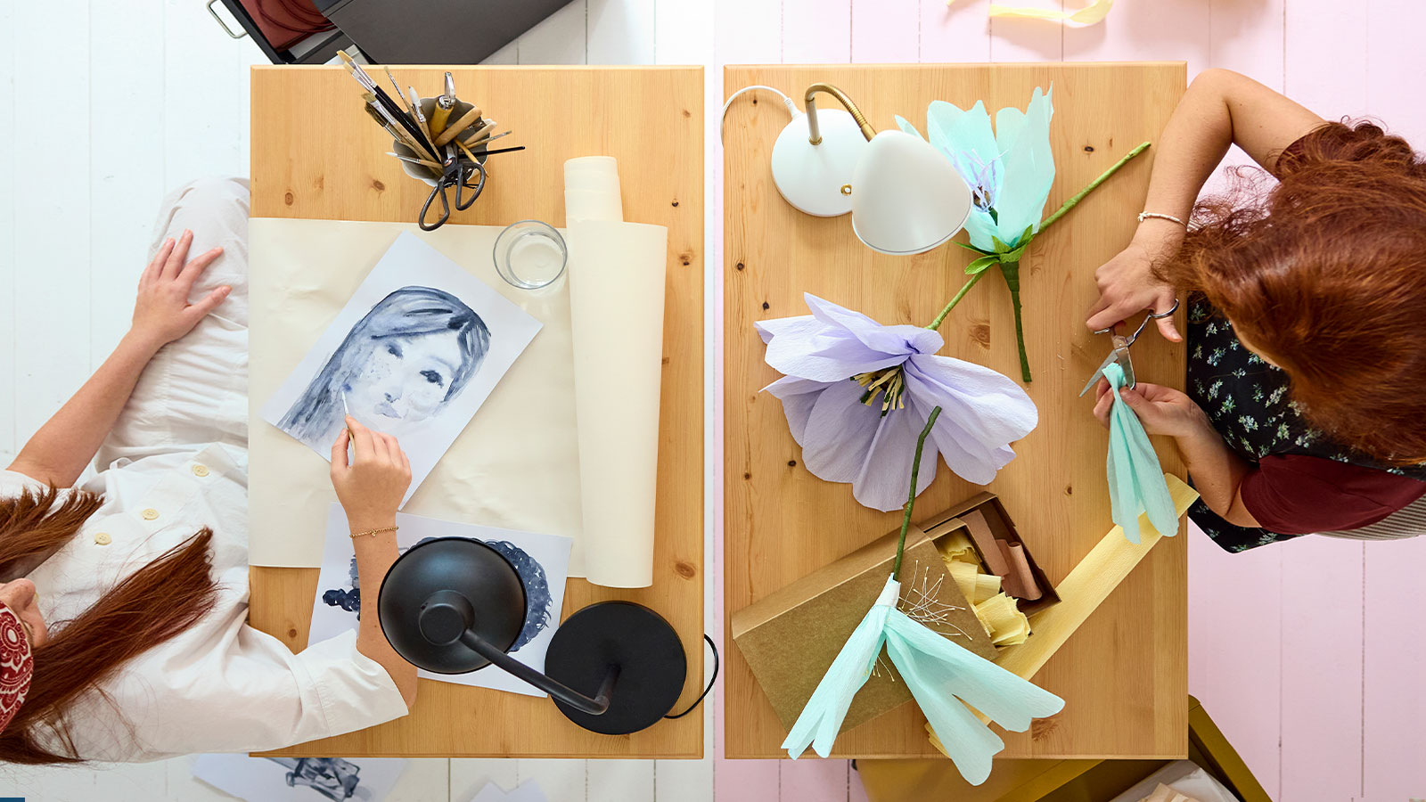 Dos escritorios BOLLPOJKE en pino/blanco uno al lado del otro, vistos desde arriba, con dos adolescentes haciendo manualidades y usando materiales de arte.
