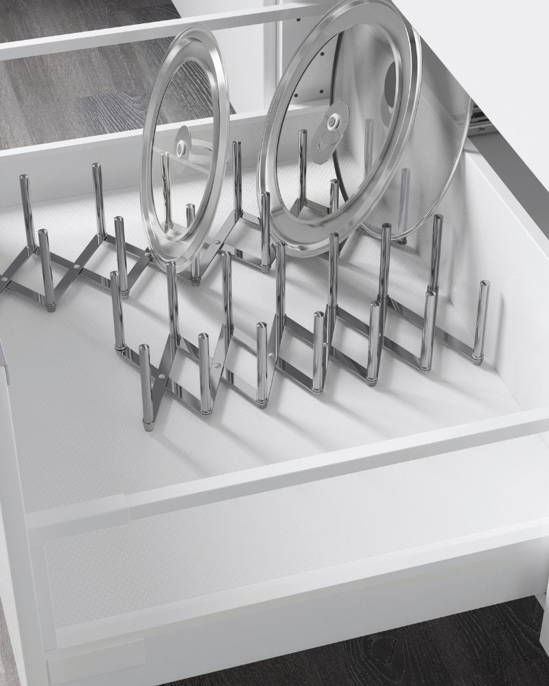 Cajón de cocina blanco con organizador metálico ajustable para tapas de ollas. Ambiente ordenado y funcional.