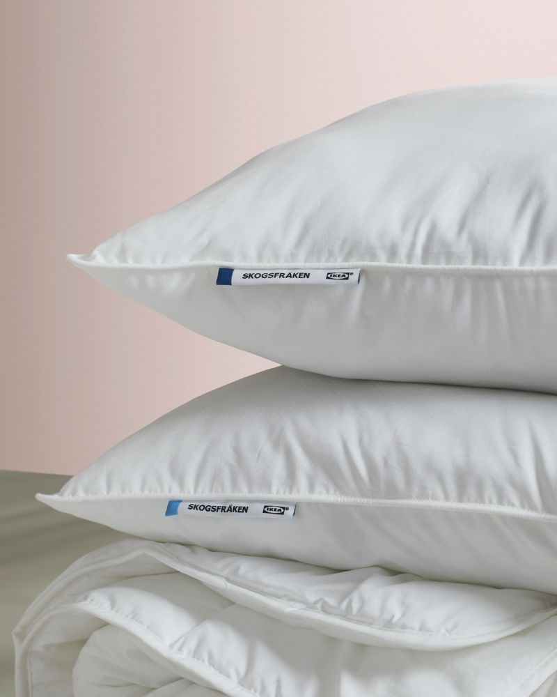 Almohadas y edredón SKOGSFRÄKEN en blanco, con acabado suave y volumen que aporta frescura y confort al descanso.