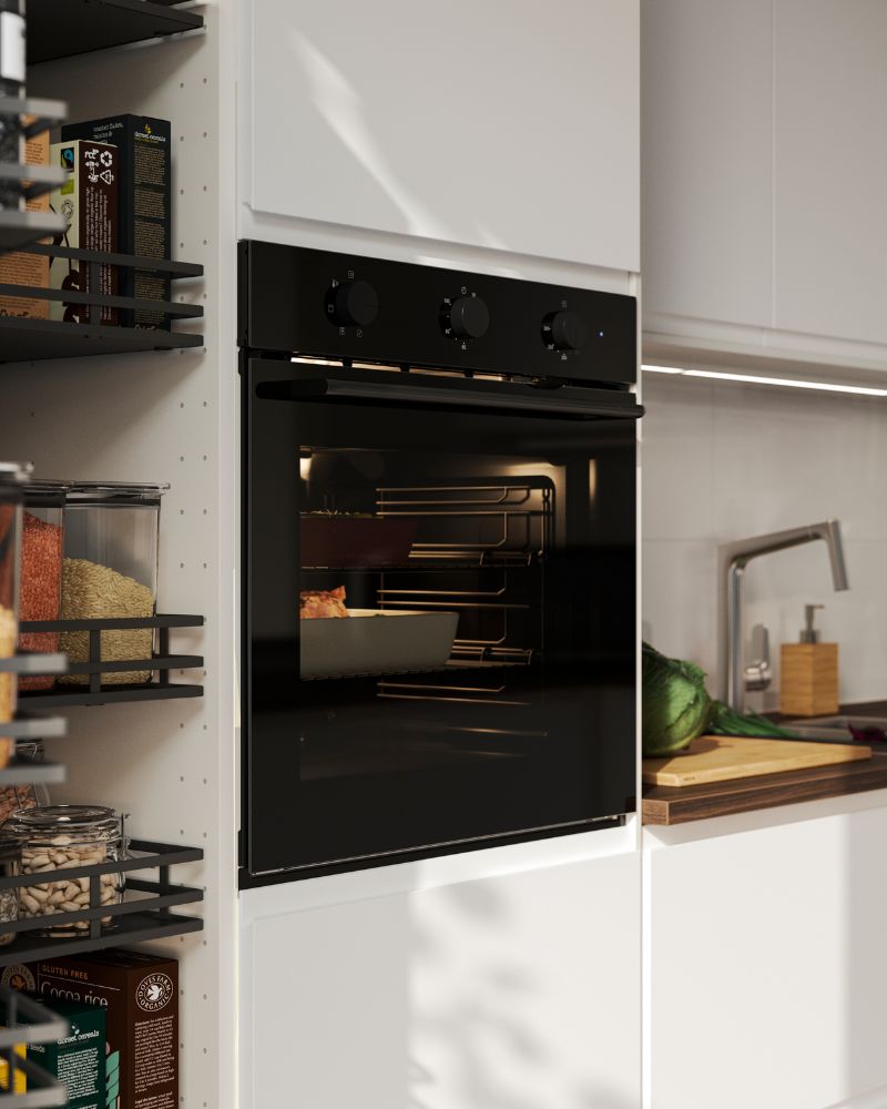 En una cocina con frentes VOXTORP en blanco mate se ve un horno con ventilador SPJUTBO de color negro, en el que se está horneando comida.