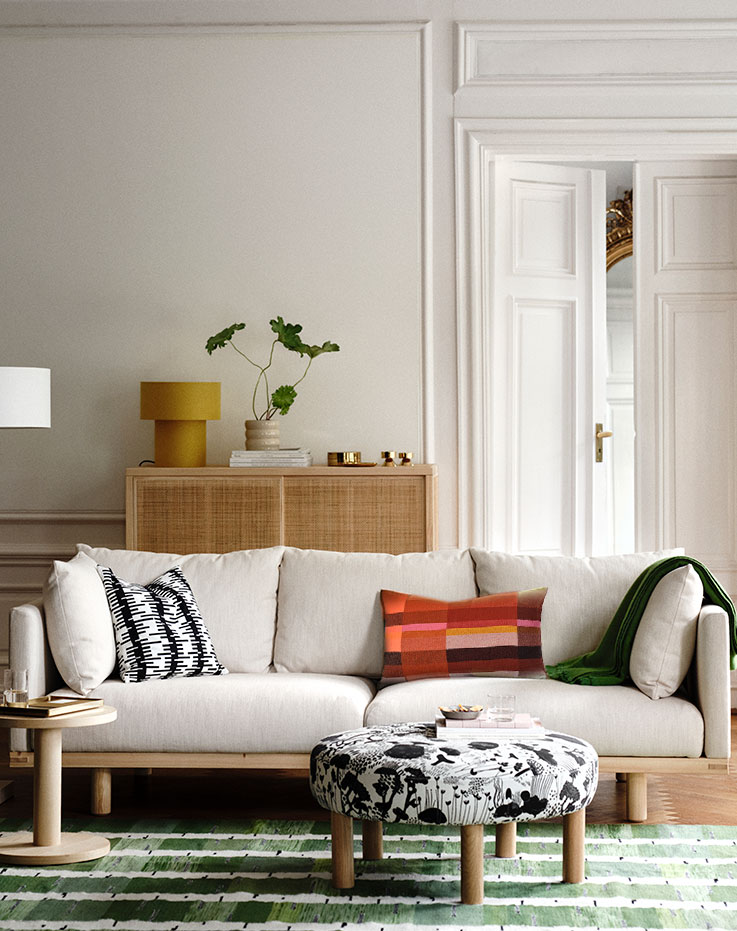 Rincón de sala con mueble cojines y mesa de centro.