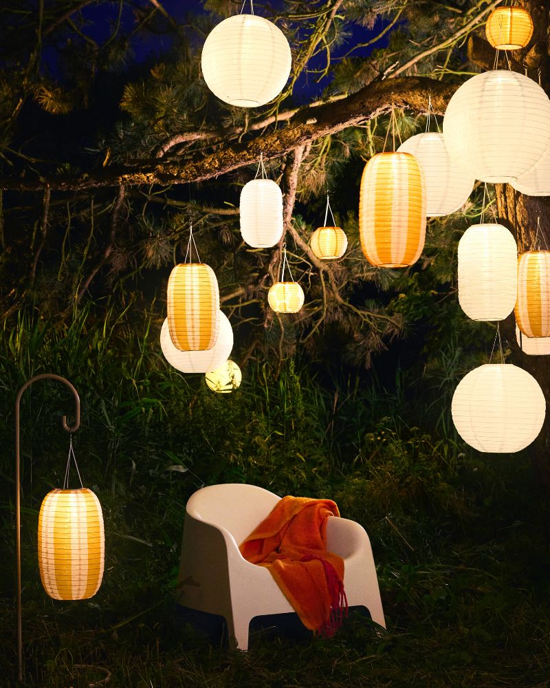 Cozy outdoor corner with SKARPÖ chair, KLIPPOXEL throw and SOLVINDEN hanging lamps for warm ambient light.