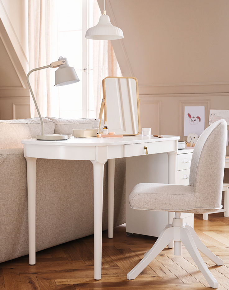 A white ROSENTORP desk and a ROSENTORP swivel chair stand behind an EKHOLMA 2-seat sofa-bed in a multipurpose living room.