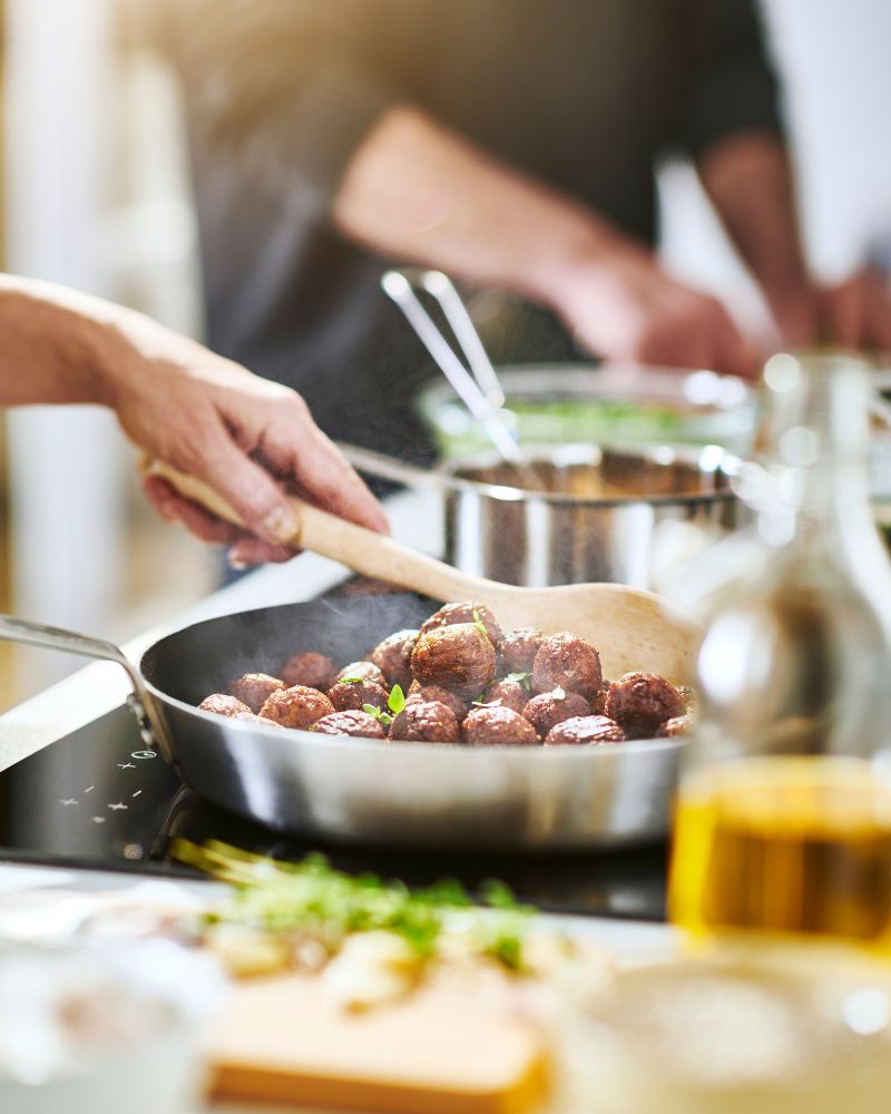 Cocina activa y funcional con cocción en proceso usando sartén HEMKOMST y albóndigas de verduras HUVUDROLL
