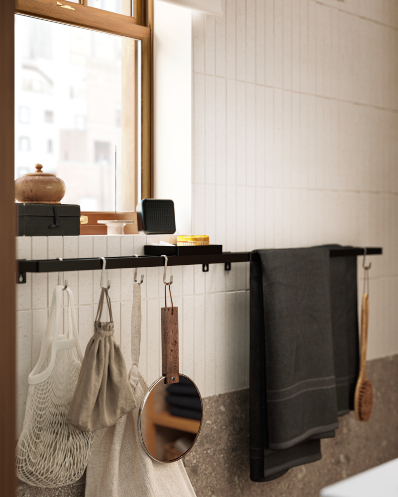Toallero negro con una toalla negra y una bolsa de malla. Un elegante complemento para el cuarto de baño