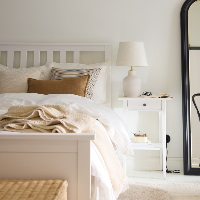 Minimalist bedroom with white bed and bedside table lamp