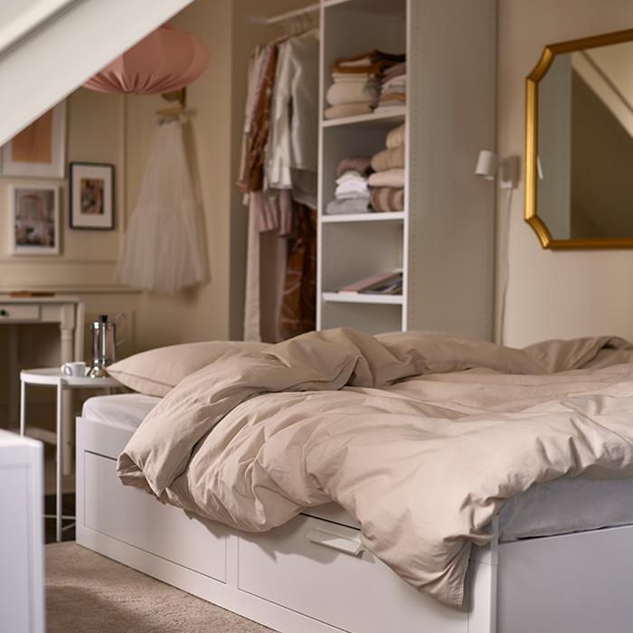 Cozy bedroom with storage bed and open wardrobe shelves