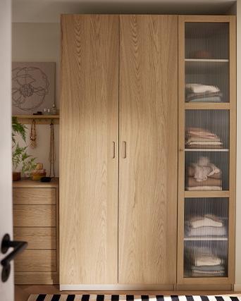 Wooden wardrobe with shelves and folded clothes inside