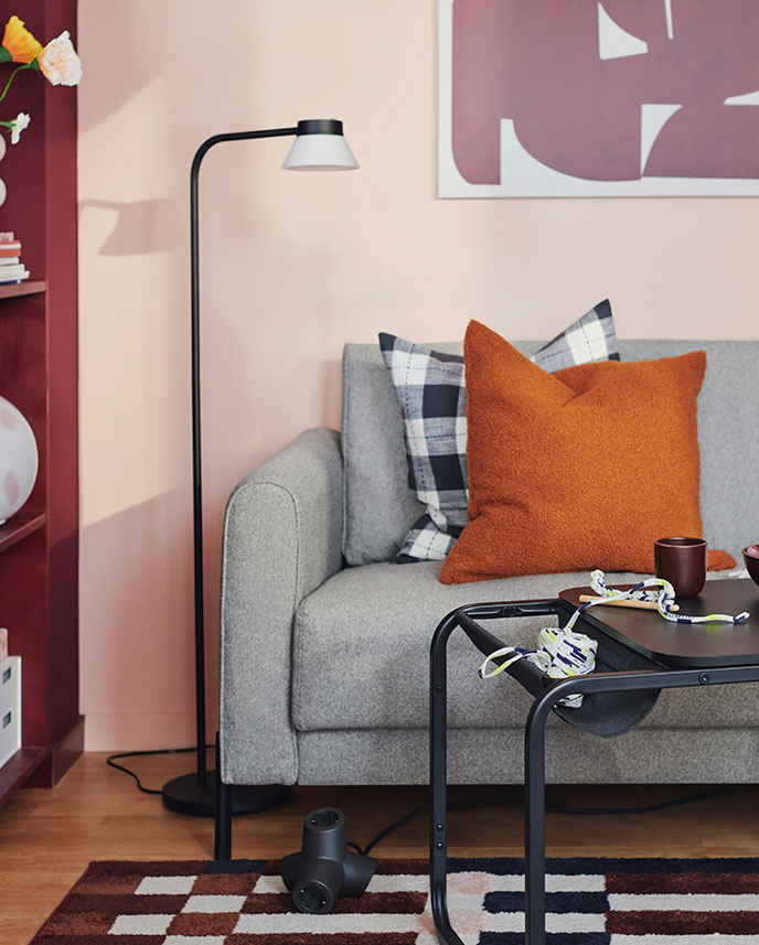 An OLSERÖD side table stands in front of a grey-beige SALTMYRAN 2-seat sofa with some extra cushions on it.