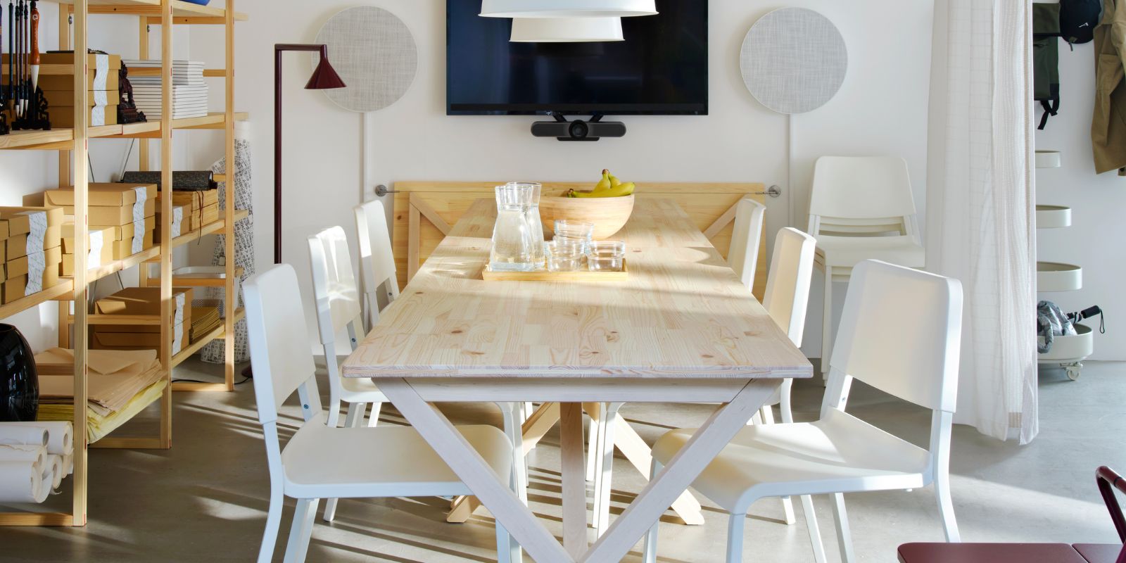 Sala de reuniones moderna con mesa IKEA PS 2026, sillas TEODORES, lámparas BUNKEFLO, bocinas SOLSKYDD y estantería IKEA PS 2026.