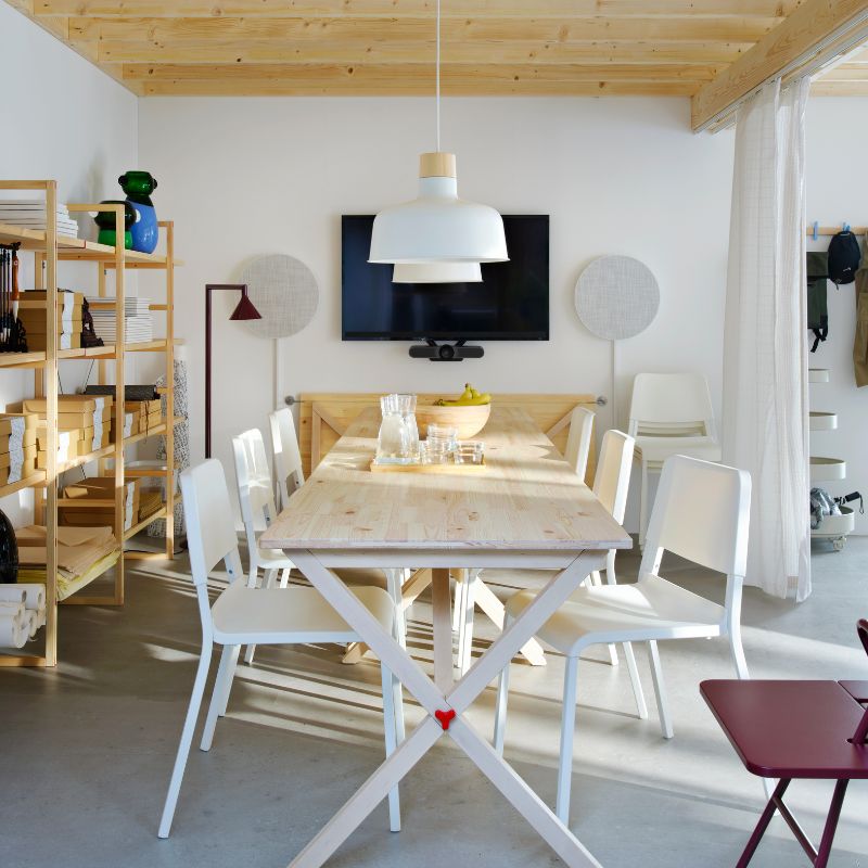 Sala de reuniones moderna con mesa IKEA PS 2026, sillas TEODORES, lámparas BUNKEFLO, bocinas SOLSKYDD y estantería IKEA PS 2026.