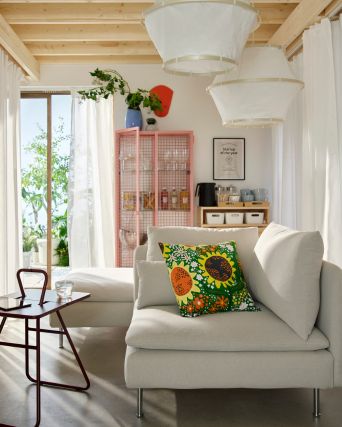 Área lounge de oficina acogedora con sofá SÖDERHAMN, mesa auxiliar IKEA PS 2026, cortinas MÄSTERROT y vitrina IKEA PS 2026.