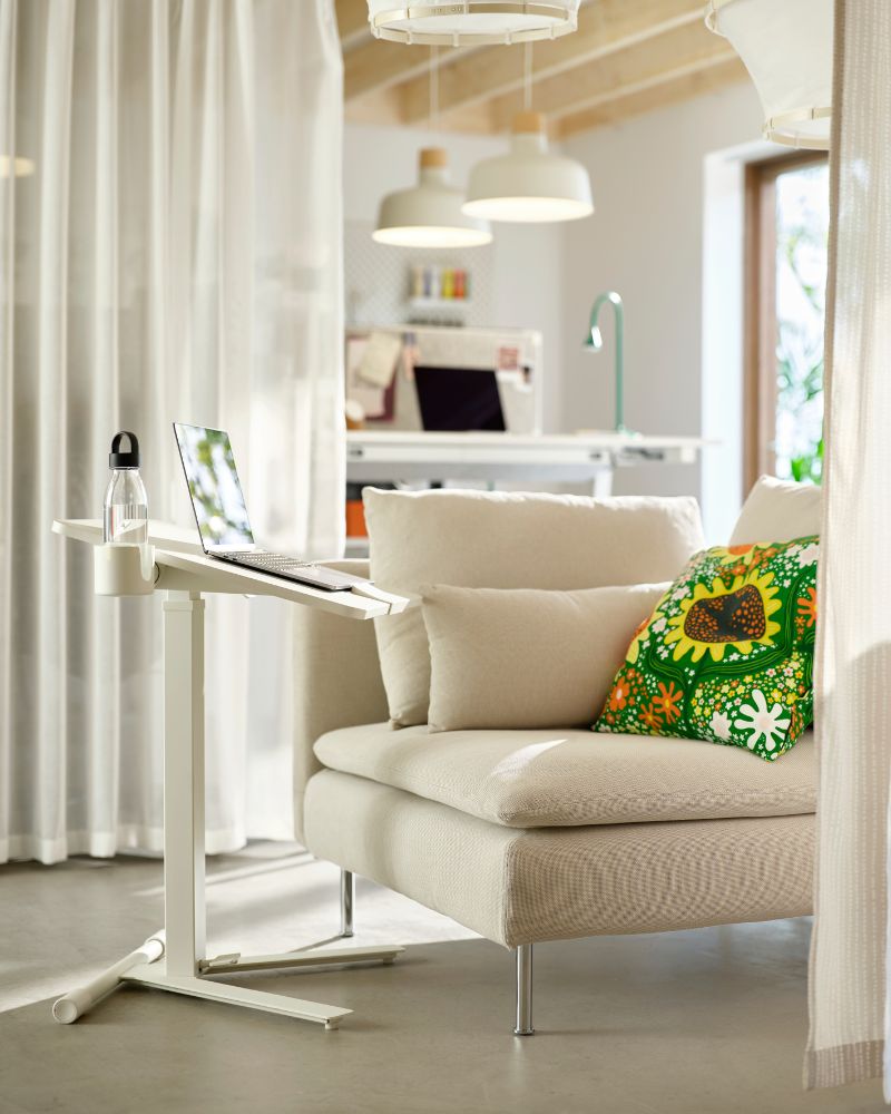 Área lounge de oficina acogedora con sofá SÖDERHAMN, cortinas MÄSTERROT, mesa MITTZON y lámpara BUNKEFLO.