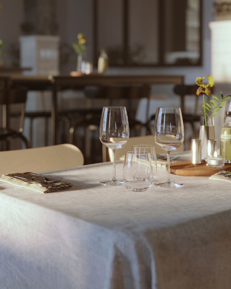 Elegant restaurant table with SILVERARV tablecloth, STORSINT wine glasses, IVRIG glass, BERÄKNA vase and RÖNNINGE chairs.