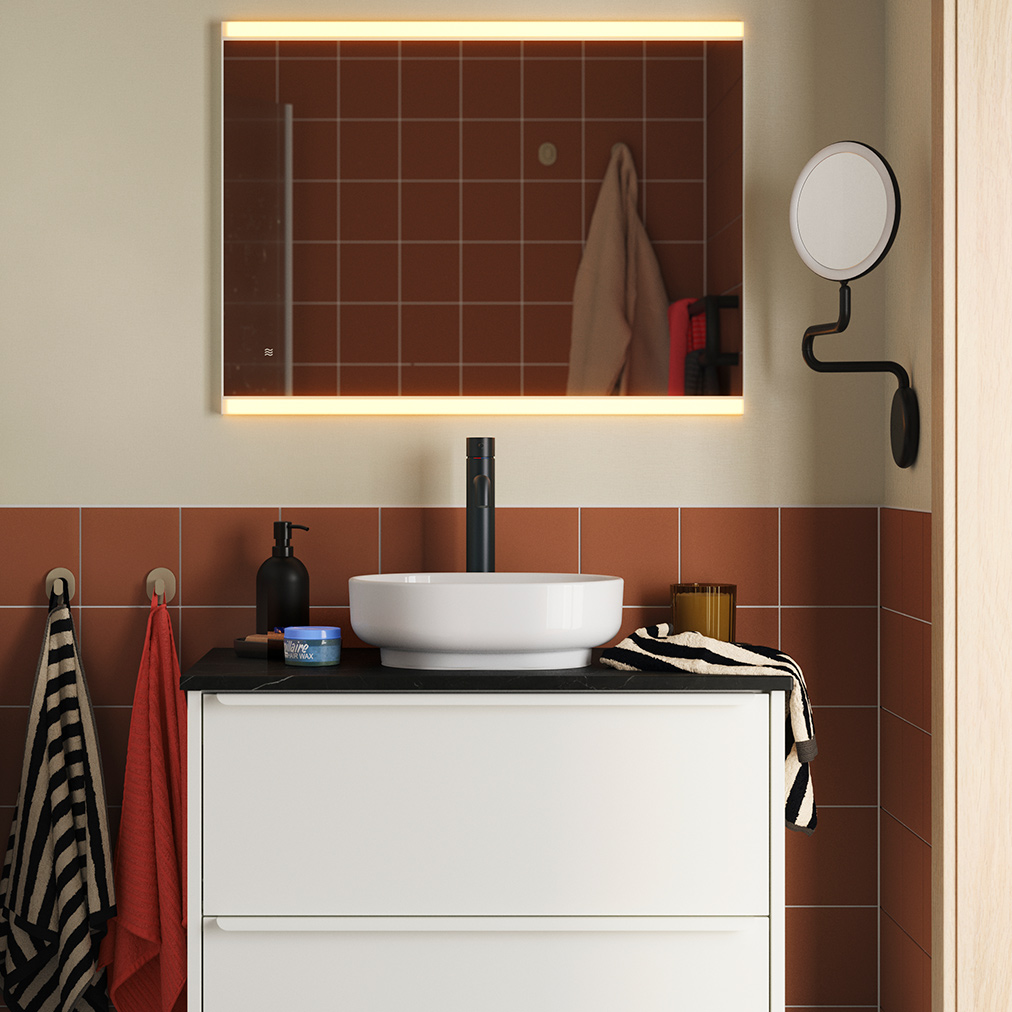 A terracotta-tiled bathroom with HAVBÄCK/VINDEÄLVEN washbasin cabinet in white, topped with a round basin and black tap.