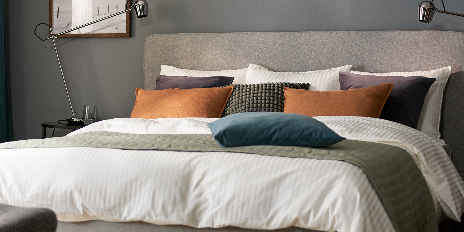 Scandinavian bedroom with light grey bed, grey bedding and clean, minimalist décor.