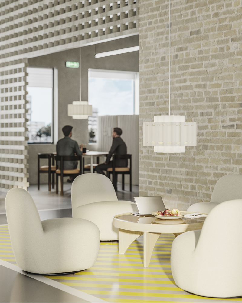 Four white easy chairs around a coffee table, set against the light brick wall of an open-plan office