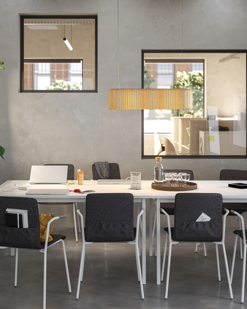 Meeting room with simple, streamlined design, featuring white tables and black upholstered conference chairs.