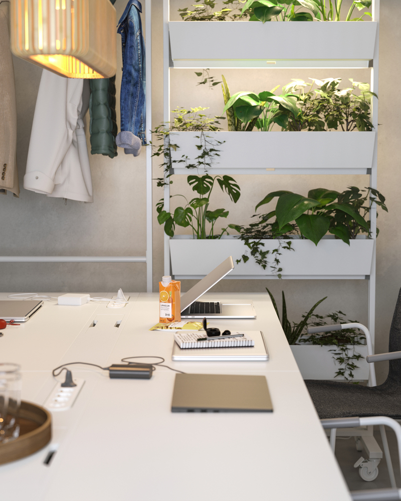 Meeting table with a compartment for charging computers and phones. Gentle lighting and plants create a soft vibe.