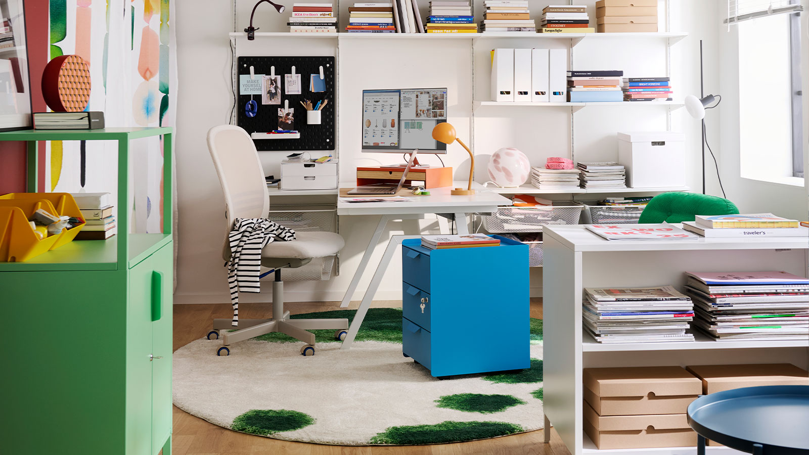 A home office features a blue TROTTEN drawer unit on castors, surrounded by shelves and a desk with stationery.