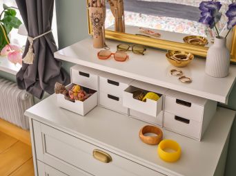 Elegant vanity area with FÅGELFJÄLLET chest, SVANSELE mirror, FJÄDERHARV mini chest and HANDSKALAD decor.
