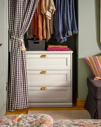 Practical dressing area with FÅGELFJÄLLET chest, FJÄDERHARV storage box, EKTORP ottoman and KORGMOTT curtains.