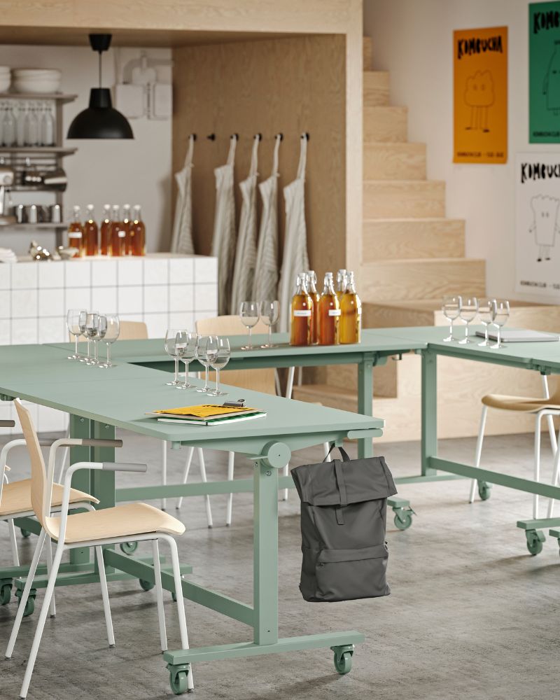 Varias mesas plegables MITTZON de color verde dispuestas en forma de U, combinadas con sillas de conferencia LÄKTARE.