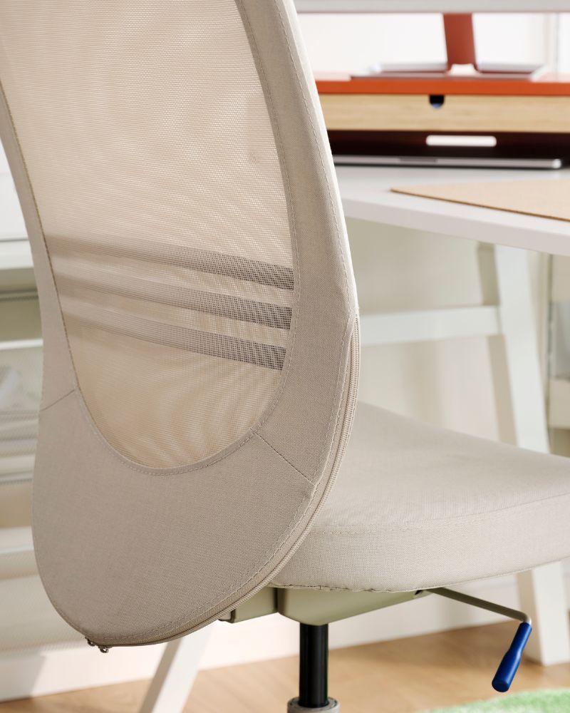 Beige mesh office chair with a white desk.