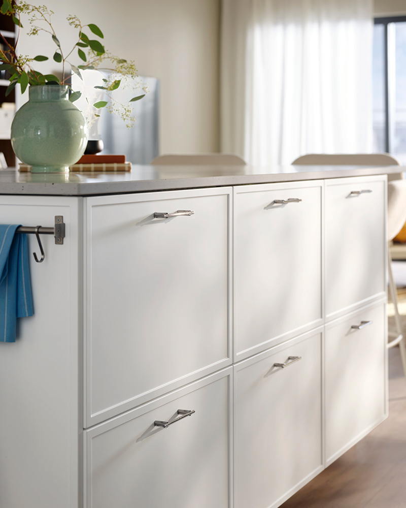 A white kitchen island featuring light grey ASPUDDEN drawer fronts and a light grey EKBACKEN countertop. 