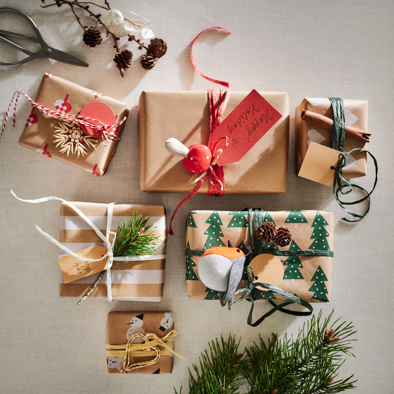 Boxes wrapped in VINTERFINT gift wrap, in various colors and sizes, on a table.