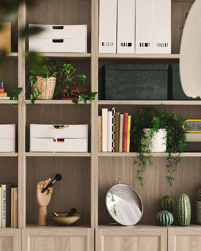 Dark wood bookcase filled with books, decorative art, and woven baskets behind a vibrant yellow sofa with cozy cushions.