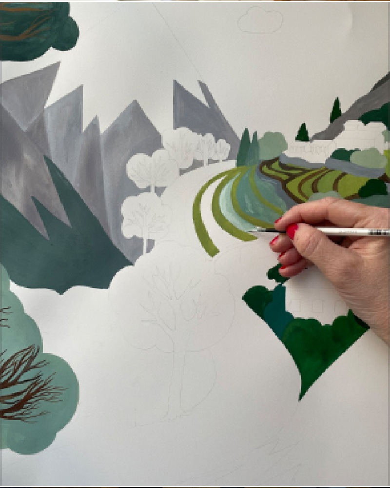 La diseñadora de ALPTALL Malin Gyllensvaan pintando a mano un paisaje del Himalaya para productos ALPTALL en la colección infantil. 