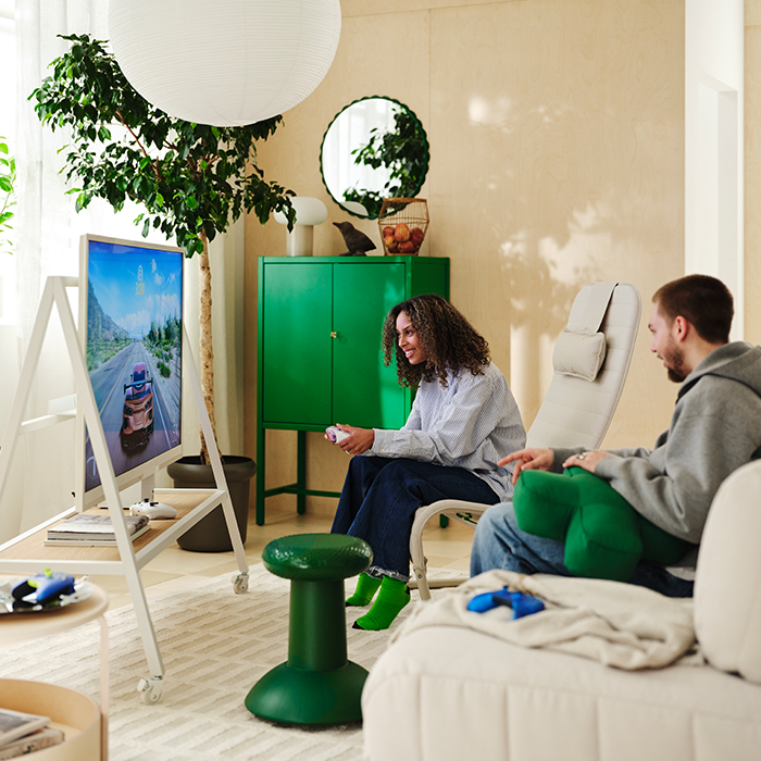 A couple is gaming in the living room surrounded by products from the YXSTABY collection.