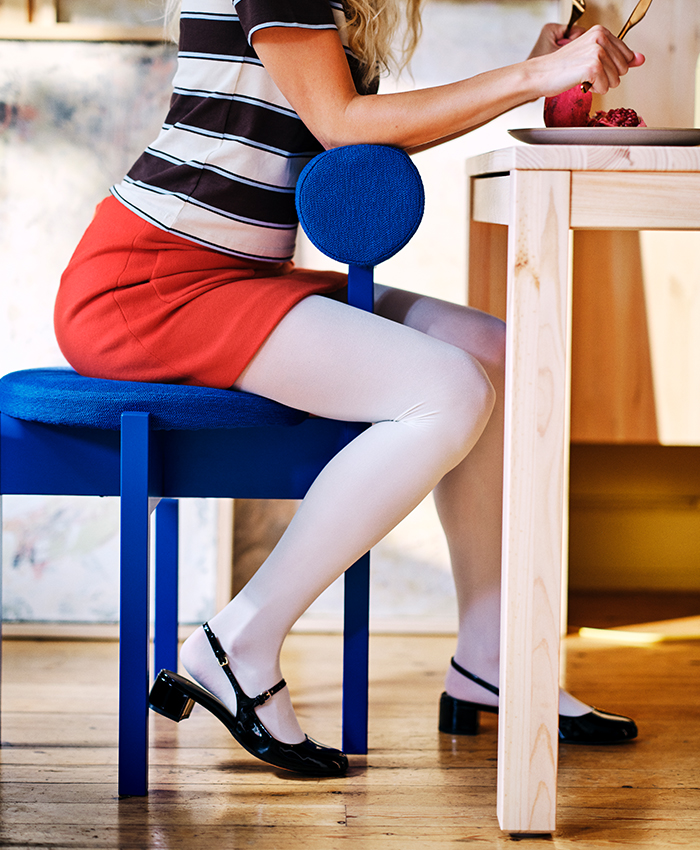 Blue upholstered IKEA PS 2026 chair beside a wooden table.