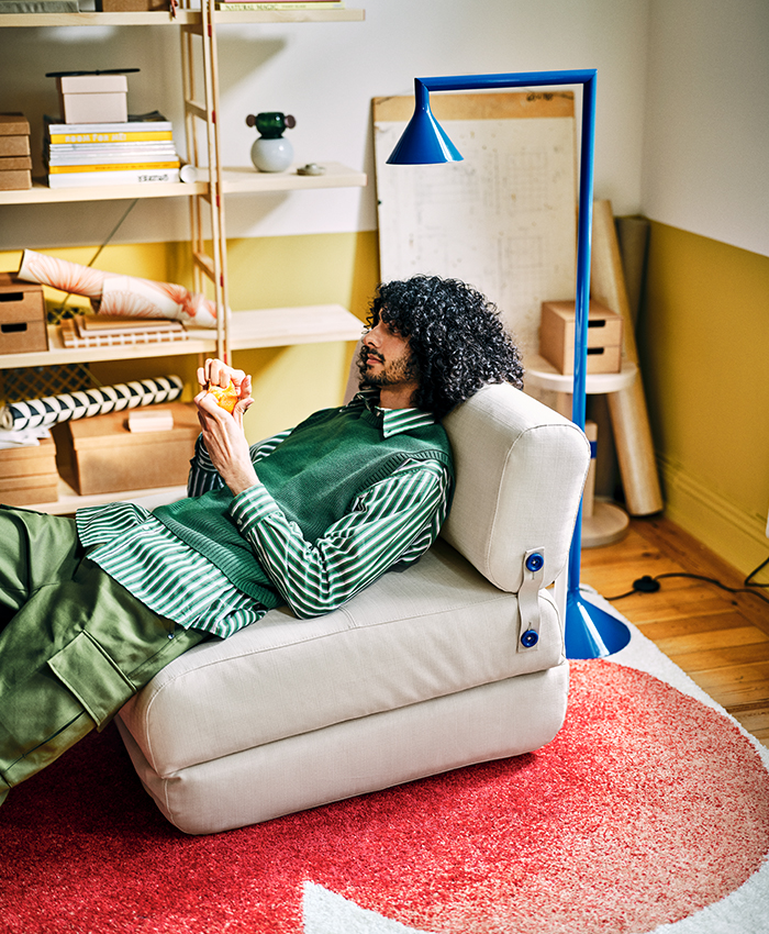 IKEA PS 2026 modular sofa with adjustable backrest and integrated blue lamp in a home workspace.