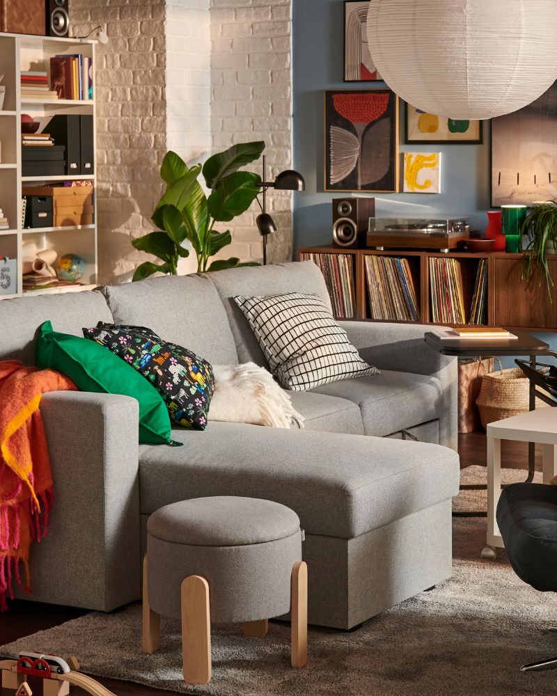 Warm living room with BÅRSLÖV sofa bed, DYVLINGE swivel chair, STOENSE rug, OLSERÖD side table and KLIPPOXEL throw.