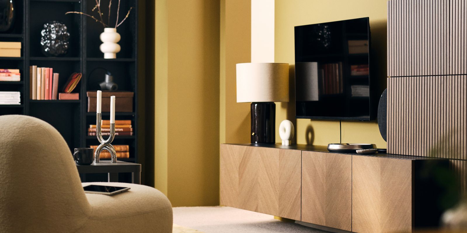 A neat, light living room with a BESTÅ storage combination with wood-veneer fronts, bookshleves and easy chair.