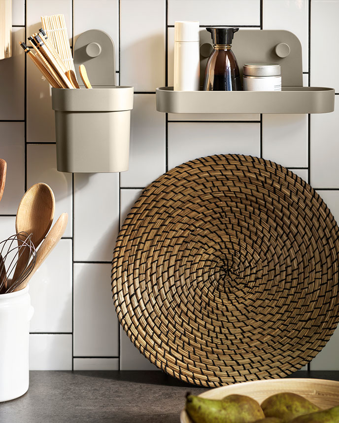 Una sección de la pared de la cocina equipada con un recipiente ÖBONÄS con ventosas y un estante de pared ÖBONÄS con ventosas.