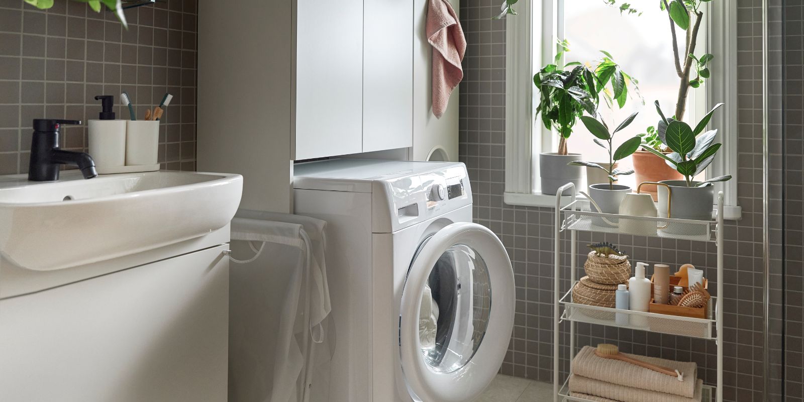 Baño funcional con armario de lavandería NYSJÖN, lavadora UDDARP, carrito HORNAVAN y accesorios STORAVAN.