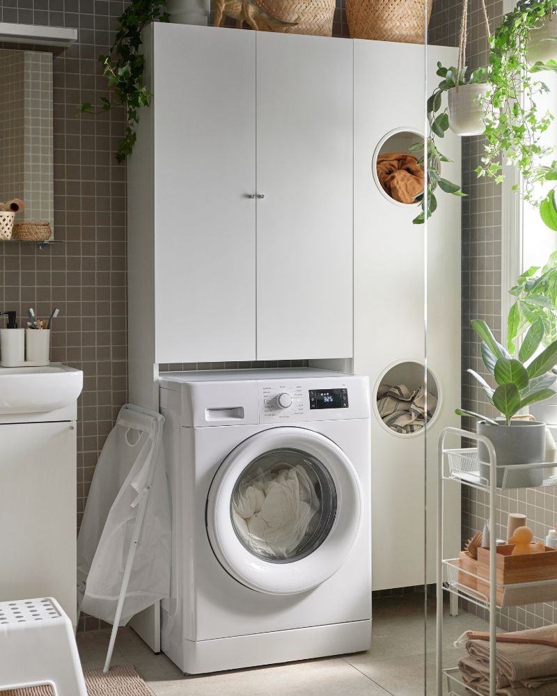 Baño funcional con zona de lavandería, armario NYSJÖN, lavadora UDDARP, carrito HORNAVAN y toallas VÅGSJÖN.