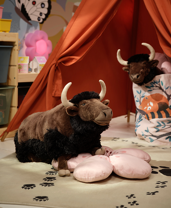 Una carpa en una habitación infantil con una alfombra de huellas de animal, en el centro un peluche de bisonte de la colección ALPTALL