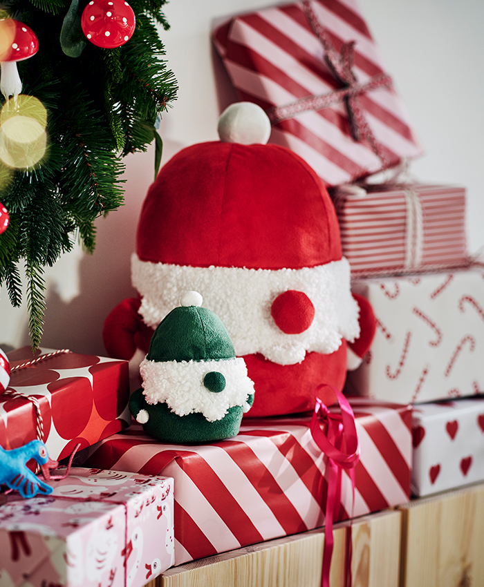 Decoración navideña VINTERFINT de IKEA, con adornos, peluches y regalos envueltos en tonos rojo, verde y blanco junto al árbol de Navidad.