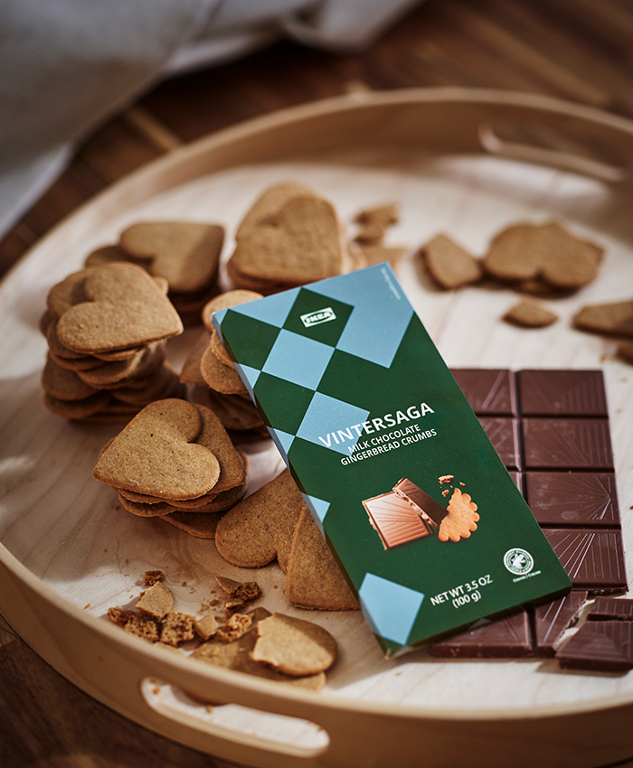 Galletas de jengibre VINTERSAGA con chocolate con leche de IKEA, servidas en una bandeja de madera junto a trozos de chocolate y más galletas.