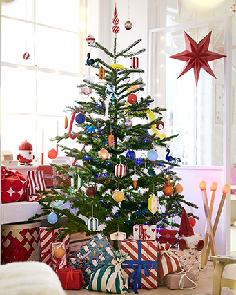 Christmas tree decorated with colourful ornaments, stars and garlands, surrounded by wrapped presents.