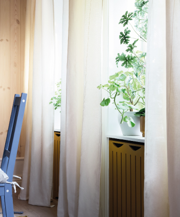 Light curtains by a window with plants.