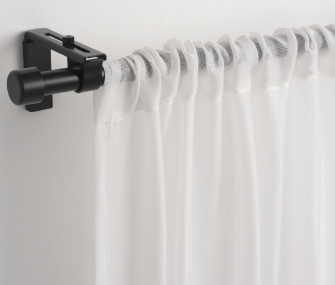 Sheer white curtain on a black rod.