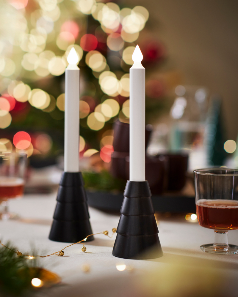 Modern candleholders with lit candles on a festive Christmas dining table setting
