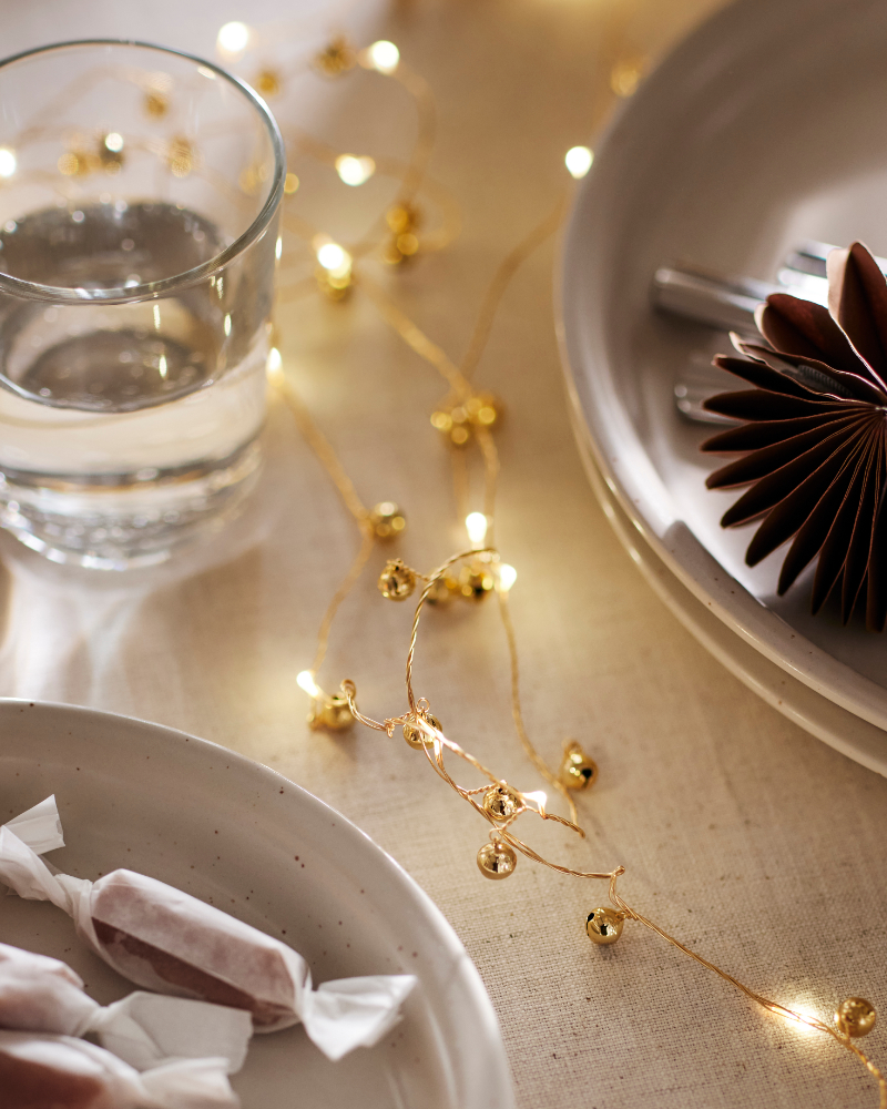 Warm golden fairy lights illuminating a festive dining table with elegant holiday decor