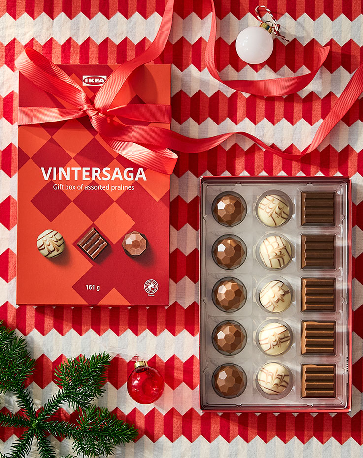 A gift box of chocolates to celebrate the holidays and share with family, placed on the table to complement the reddish hues of the season.